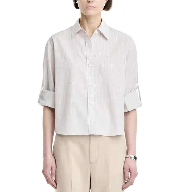A person wearing a light-colored Maria McManus Button Sleeve Crop Shirt with beige pants, standing against a plain white background.