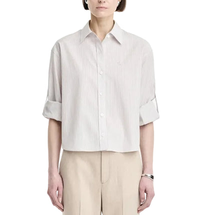 A person wearing a light-colored Maria McManus Button Sleeve Crop Shirt with beige pants, standing against a plain white background.