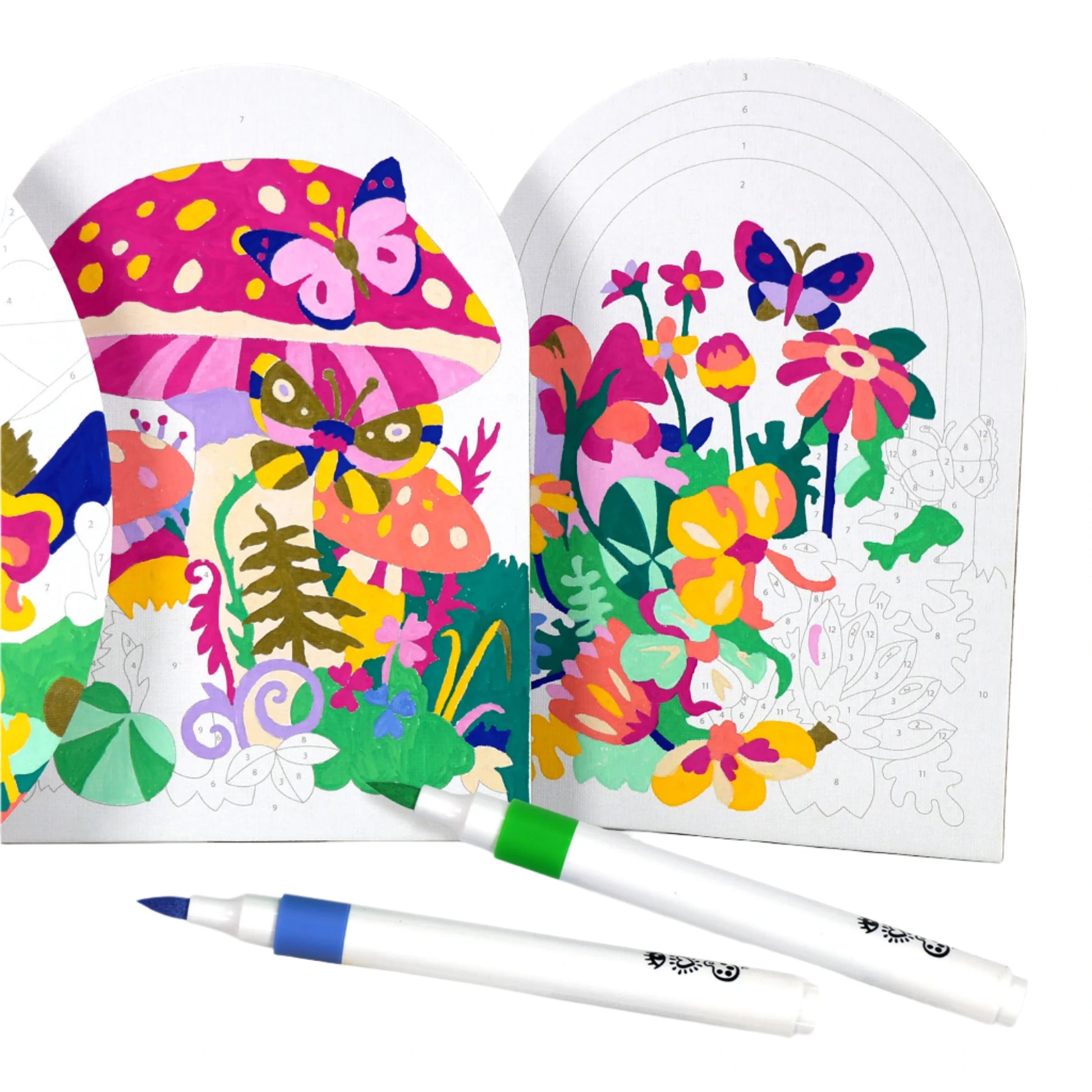 The Bright Stripes Marker By Number from Bright Stripes features vibrant illustrations of mushrooms, butterflies, and flowers in a fantasy fields setting, partially colored with nearby blue and green acrylic markers.