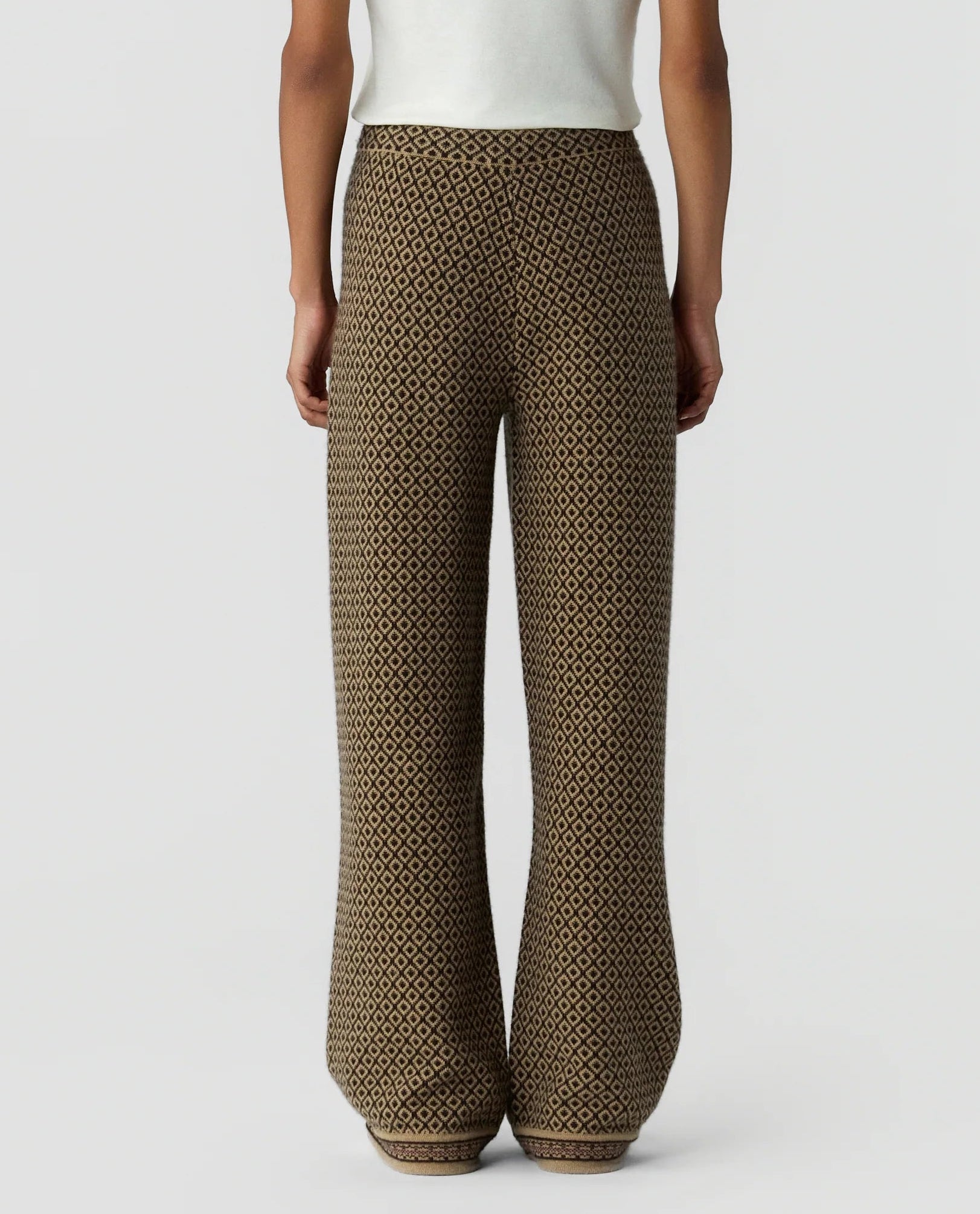 A person is shown from the back against a plain background, wearing the Guest in Residence Marquise Pant—high-waisted, wide-leg trousers featuring a brown and black geometric diamond pattern and a comfortable drawstring waist.