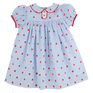The Beaufort Bonnet Company's Girls' Mary Dal Dress features a light blue color, puffed sleeves, red apple patterns, red trim, and a white button on the collar—perfect for your little "Apple of My Eye.