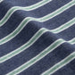 A close-up of an original fabric with horizontal navy blue and white stripes mirrors the slightly wavy texture of a Johnnie-O Matthis Polo.