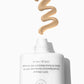 A white tube of Supergoop Mineral Mattescreen SPF 40 dispenses a swirl of beige mineral sunscreen on a white background, showcasing its mattifying, tinted formula that blurs pores.