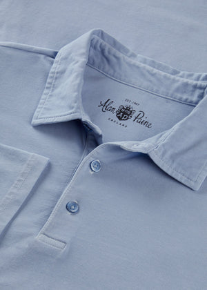 Close-up of the Tutbury Faded Dye Jersey Polo in light blue, featuring three buttons and “Alan Paine” branding on the inner collar, designed with a flexible fit for comfort—making it an ideal casual summer shirt.