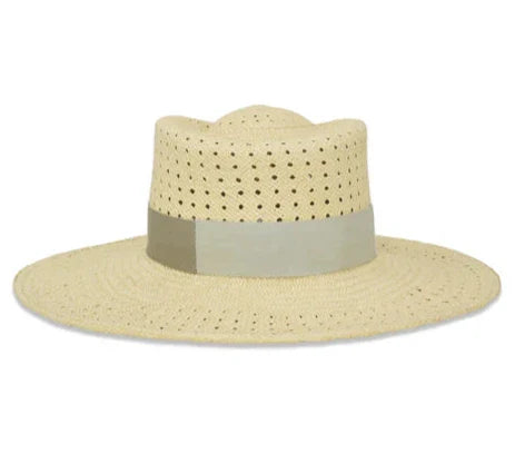 The Gigi Burris Merle Hat from Gigi Burris is a Panama straw hat with a wide brim and a perforated design, adorned with a light grey ribbon around the base of the crown. It's perfect for your summer wardrobe and is handcrafted in New York City for timeless elegance.