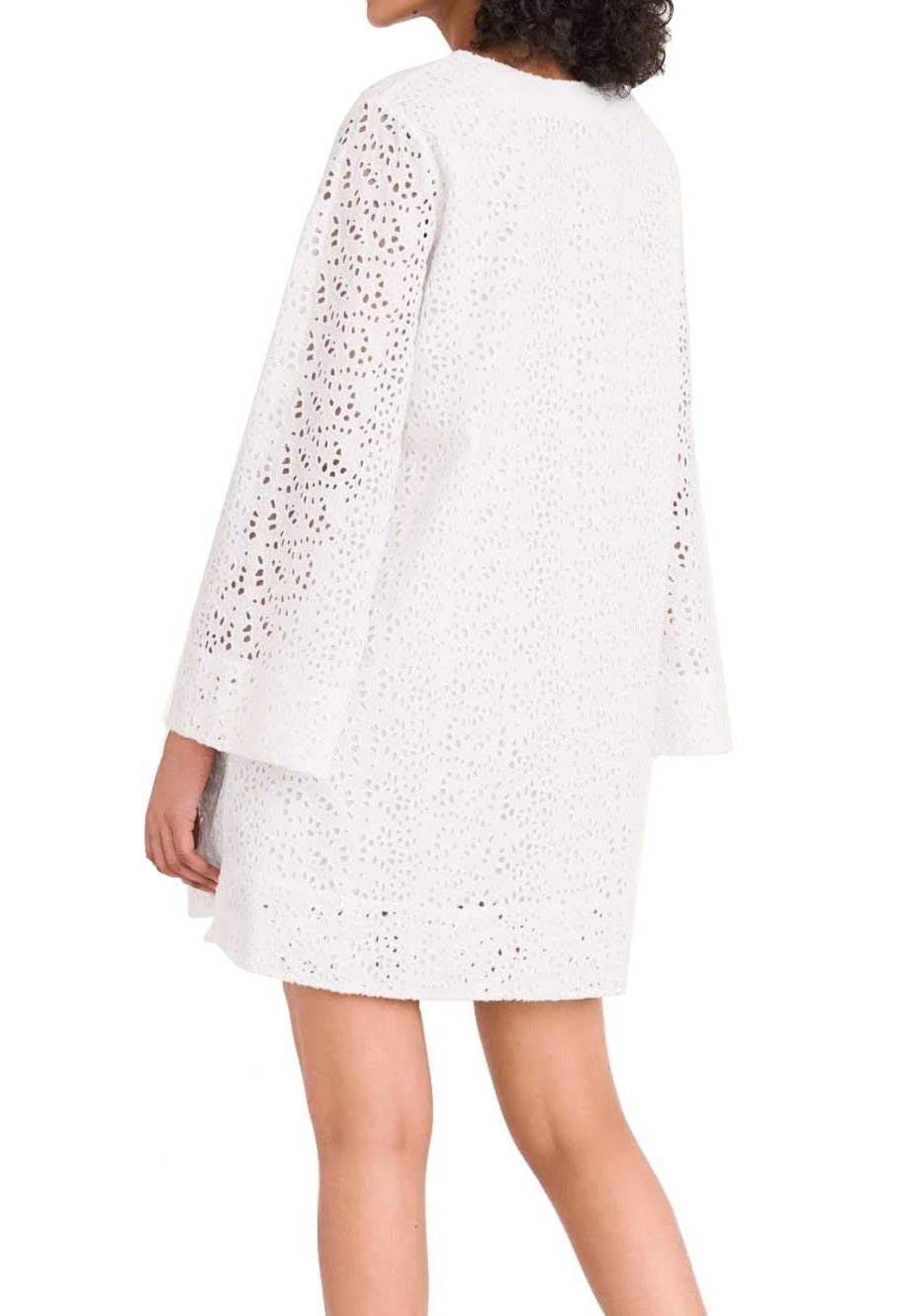 Woman wearing a white cotton eyelet Merlette Charme Dress with a perforated pattern, viewed from the back by Merlette New York.