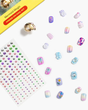 Introducing the Super Smalls Mermaid Press On Nail Kit, featuring ocean-inspired colorful mermaid press-on nails, a sheet of gem stickers, and a gold nail accessory—all displayed on a white background.