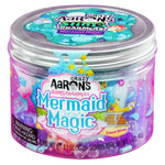 The "Mermaid Magic" edition of Crazy Aaron's Slime Charmers comes in a plastic container featuring textured mixers for an enchanting play experience. The transparent lid offers a view of colorful imagery and delightful charms swirling inside.