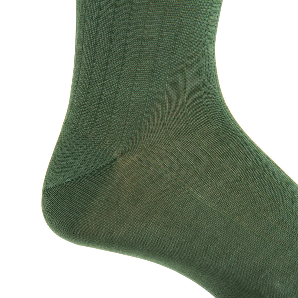 Close-up of a person’s foot and ankle wearing the Forest Green Ribbed Cotton Sock Linked Toe Mid-Calf by Dapper Classics, photographed against a white background.