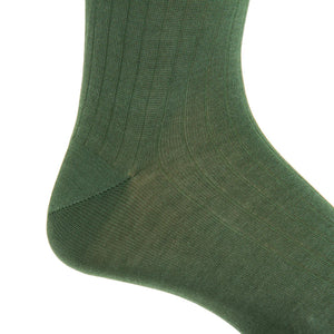 Close-up of a person’s foot and ankle wearing the Forest Green Ribbed Cotton Sock Linked Toe Mid-Calf by Dapper Classics, photographed against a white background.