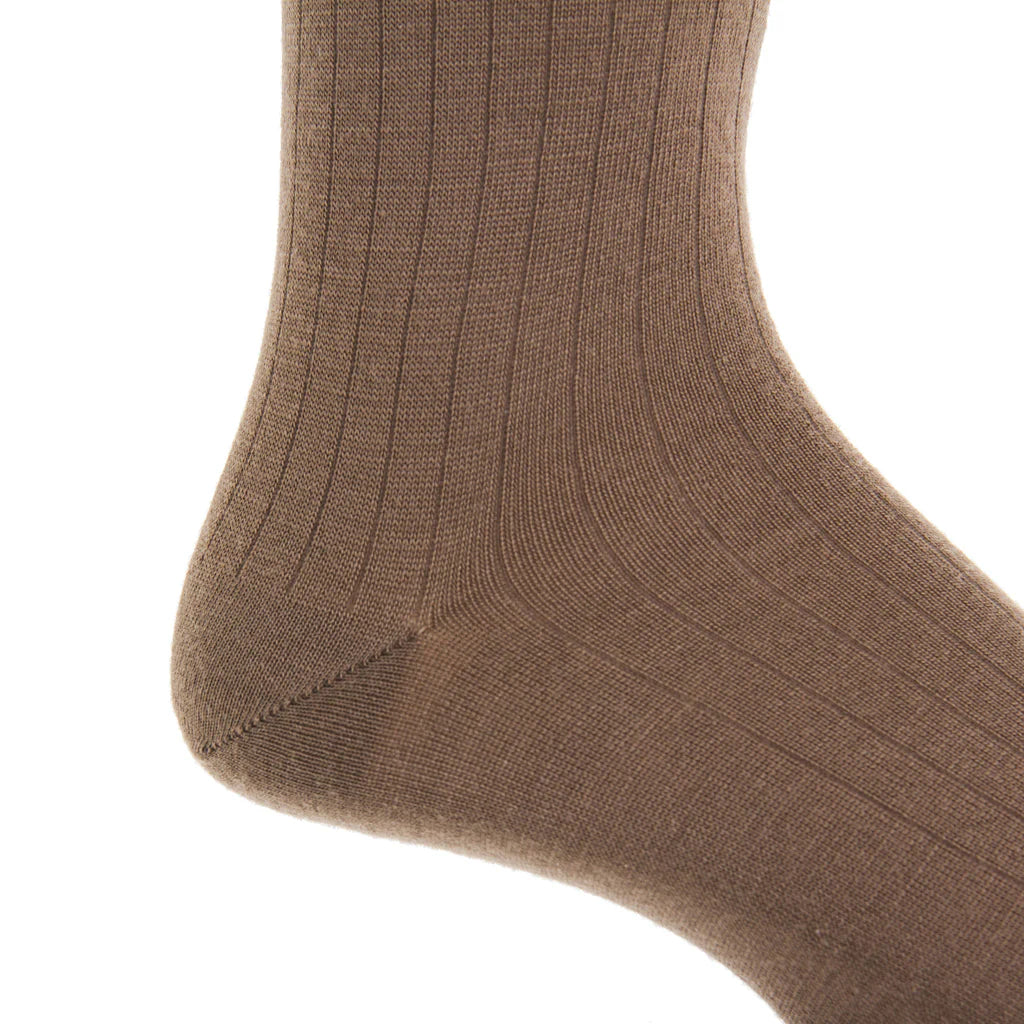 Close-up of a Dapper Classics Mushroom Solid Ribbed Fine Merino Wool Sock on a foot, highlighting the texture and stitching near the heel and ankle. Expertly crafted men's mid-calf dress sock with linked toe, made in North Carolina.
