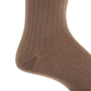 Close-up of a Dapper Classics Mushroom Solid Ribbed Fine Merino Wool Sock on a foot, highlighting the texture and stitching near the heel and ankle. Expertly crafted men's mid-calf dress sock with linked toe, made in North Carolina.