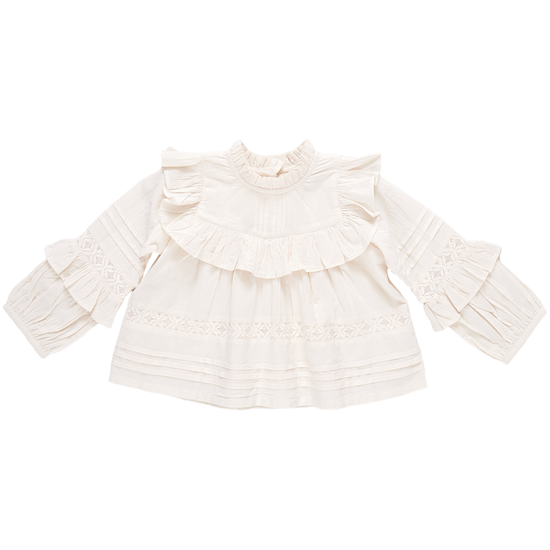 The Pink Chicken Girls' Lace Mira Top, crafted from 100% cotton cambric, is a white blouse with long sleeves, adorned with elegant ruffle details on the front and sleeves.