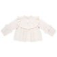 A cream-colored Lace Mira top by Pink Chicken, featuring long sleeves, a ruffled collar, and decorative lace detailing, made from 100% cotton cambric.