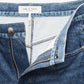 Close-up of blue denim-look Miramar Sofie Ankle pants by Rag & Bone, featuring an open zipper, waistband, label, and metal button.