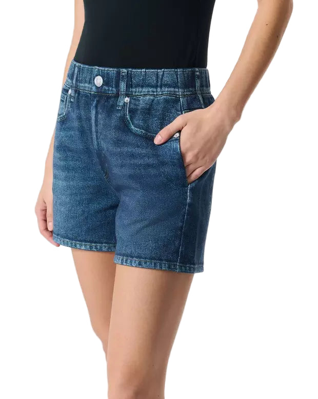 A person wearing Rag & Bone's Miramar Terry Walking Short, styled with a black top and a hand in the pocket, shown from waist to mid-thigh.