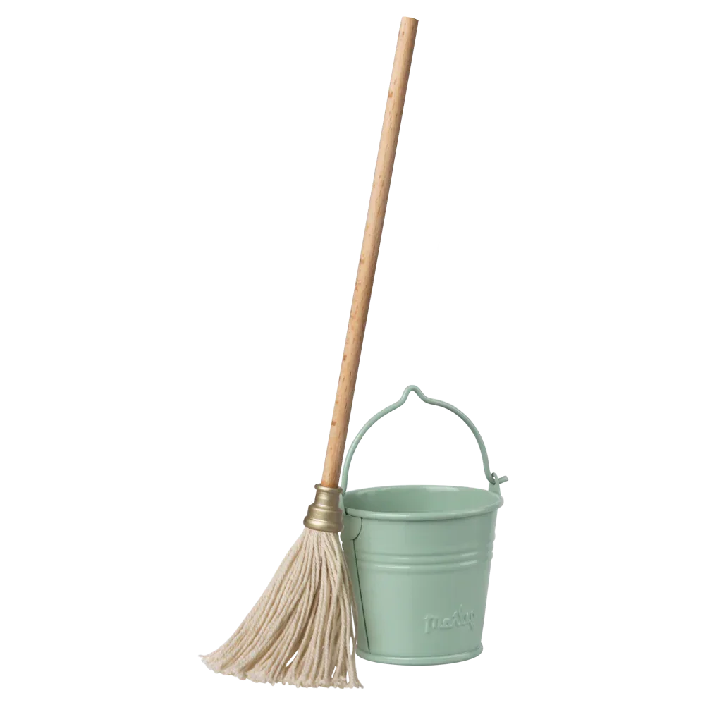 The Maileg Bucket & Mop set features a wooden-handled mop with white fibers and a light green plastic bucket with a handle, making it perfect for tiny Maileg buddies in their charming dollhouse.