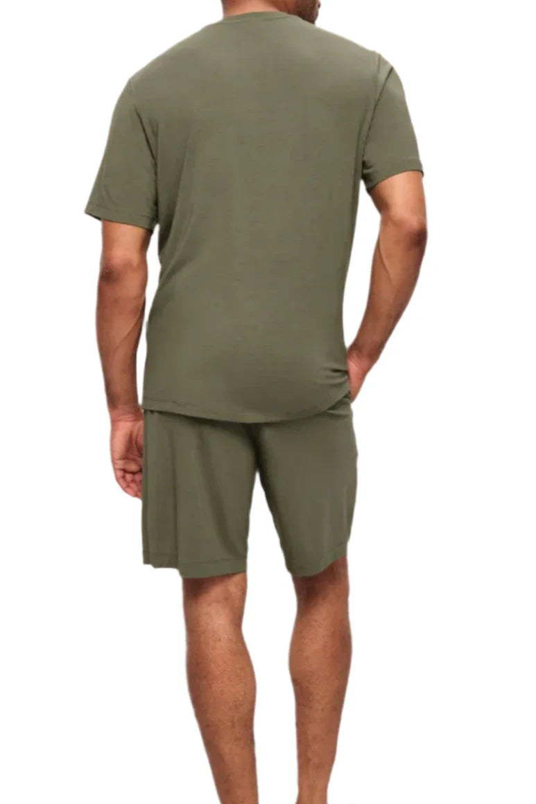 A person in the Eberjey Henry Short PJ Set by Eberjey, comprising an olive green T-shirt and matching shorts made from temperature-regulating TENCEL™ Modal, is seen from the back against a plain white background.