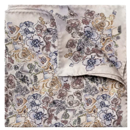 The Eton Multi Floral Silk Pocket Square features a folded design with a floral motif, displaying subtle shades of blue, purple, yellow, and brown on a light background.