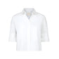 The TWP Next Ex Shirt is a white, short-sleeved, collared button-up with a chest pocket and boxy silhouette, shown against a plain background.