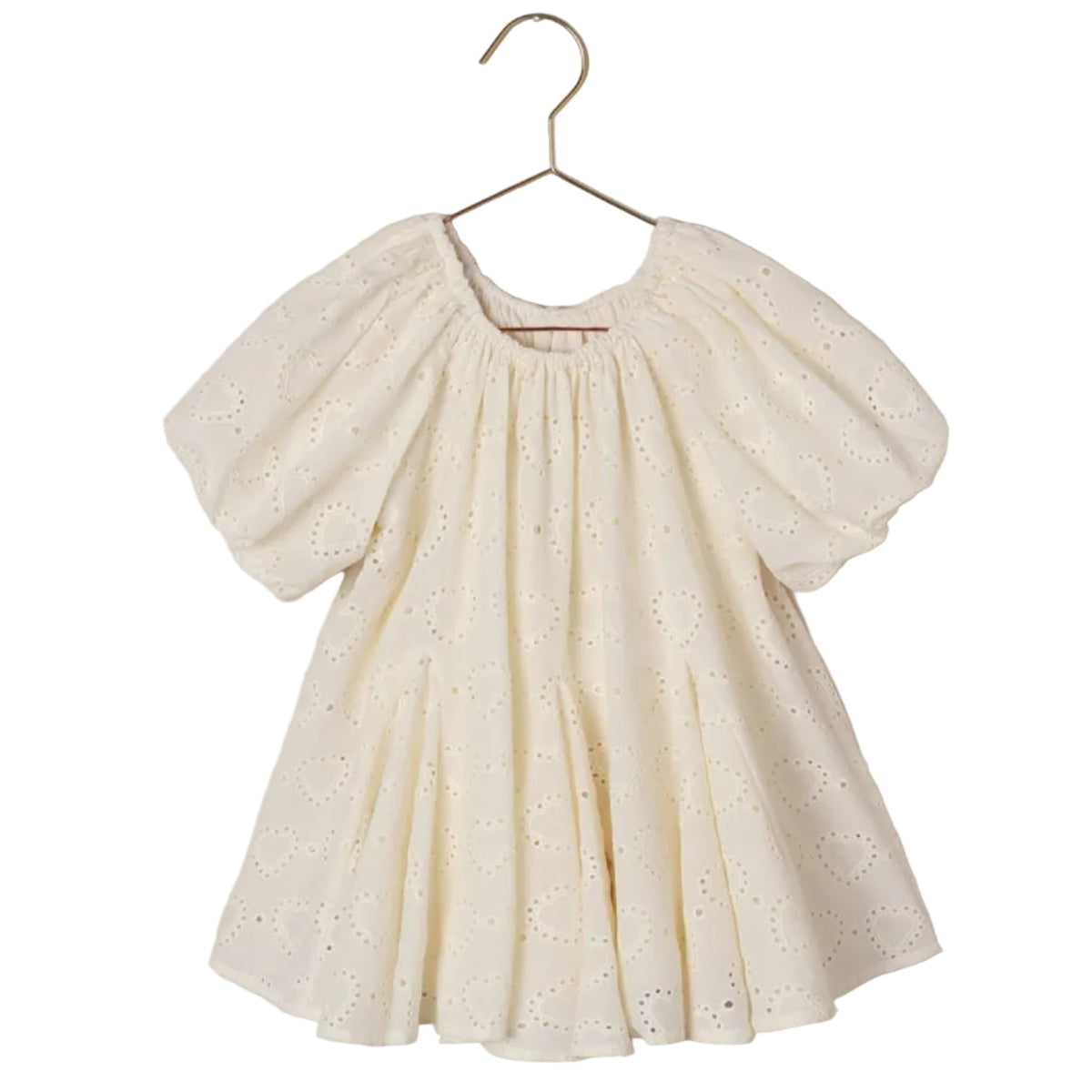 A cream-colored Noralee Baby Girls’ and Girls’ Maia Dress, featuring short sleeves and delicate embroidered heart eyelet detailing, hangs on a gold hanger against a white background.
