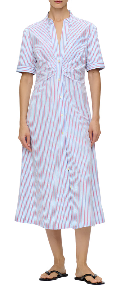 A person wearing the Noor Dress, a blue and red striped midi-length shirt dress with short sleeves by Callas Milano, paired with black flip-flops.