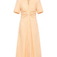 The Noor Dress by Callas Milano is a peach fit and flare midi shirt dress featuring short sleeves, a v-neck, button-down front, and ruched waist detail for a flattering silhouette.
