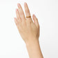 A left hand with neatly trimmed nails wears the Nanna Ring by Lie Studio—a classic curved band made of 18 carat gold-plated sterling silver—on the middle finger, set against a plain white background.