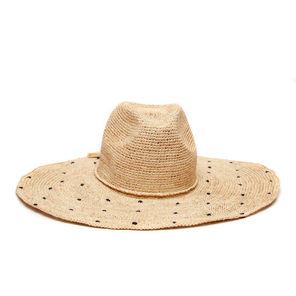 The Mar Y Sol Natalia Hat is a wide-brimmed sun hat with small black polka dots on its woven straw brim, shown in a side view against a white background.