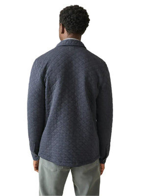 A person wearing the Faherty Epic Quilted Fleece in a dark gray hue and relaxed-fit gray pants, embodying the feel of a midweight masterpiece, is facing away from the camera.
