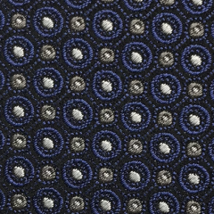 Close-up of the Robert Jensen Circle Dot Pattern Tie featuring blue and white circular designs on a dark background, showcasing an artistic expression reminiscent of traditional artisans.