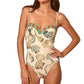 A woman wears the Nevis One Piece by Hunter Bell NYC, a flattering swimsuit with a shell and sea-inspired print, thin straps, and striped trim along the top.