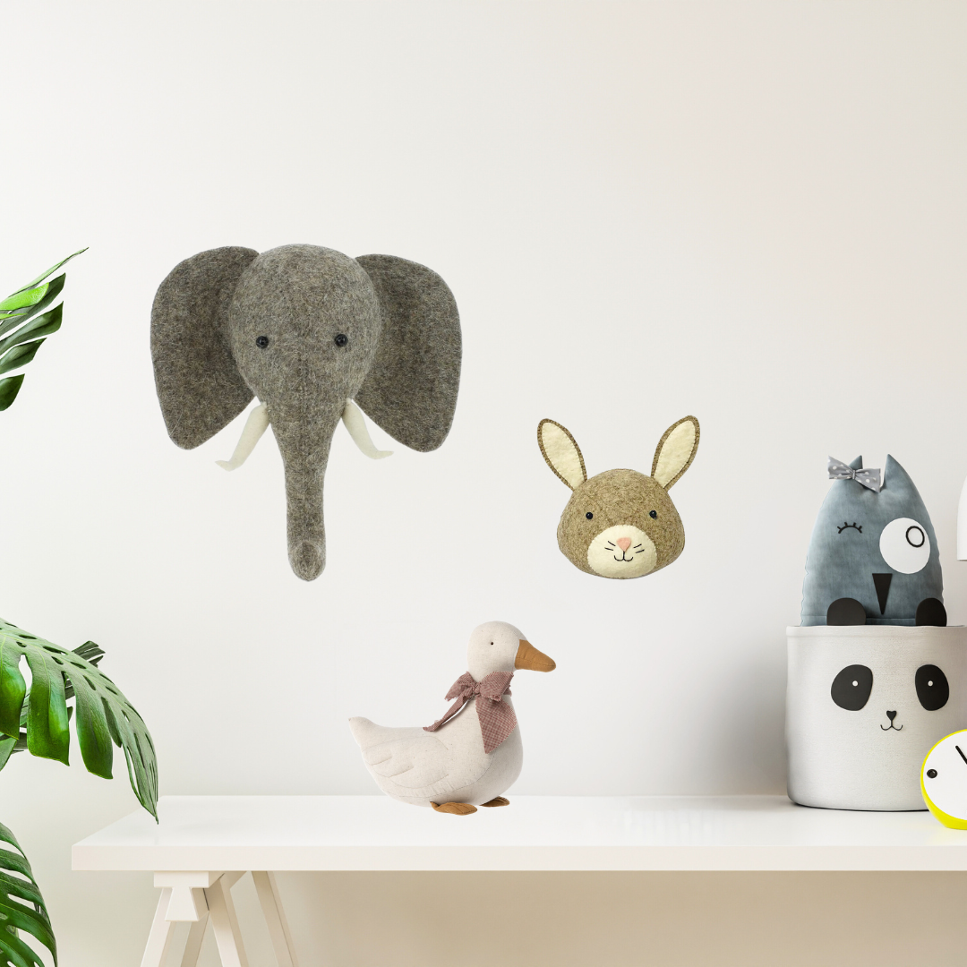 Fiona Walker wool felt animal heads hanging on a white wall.