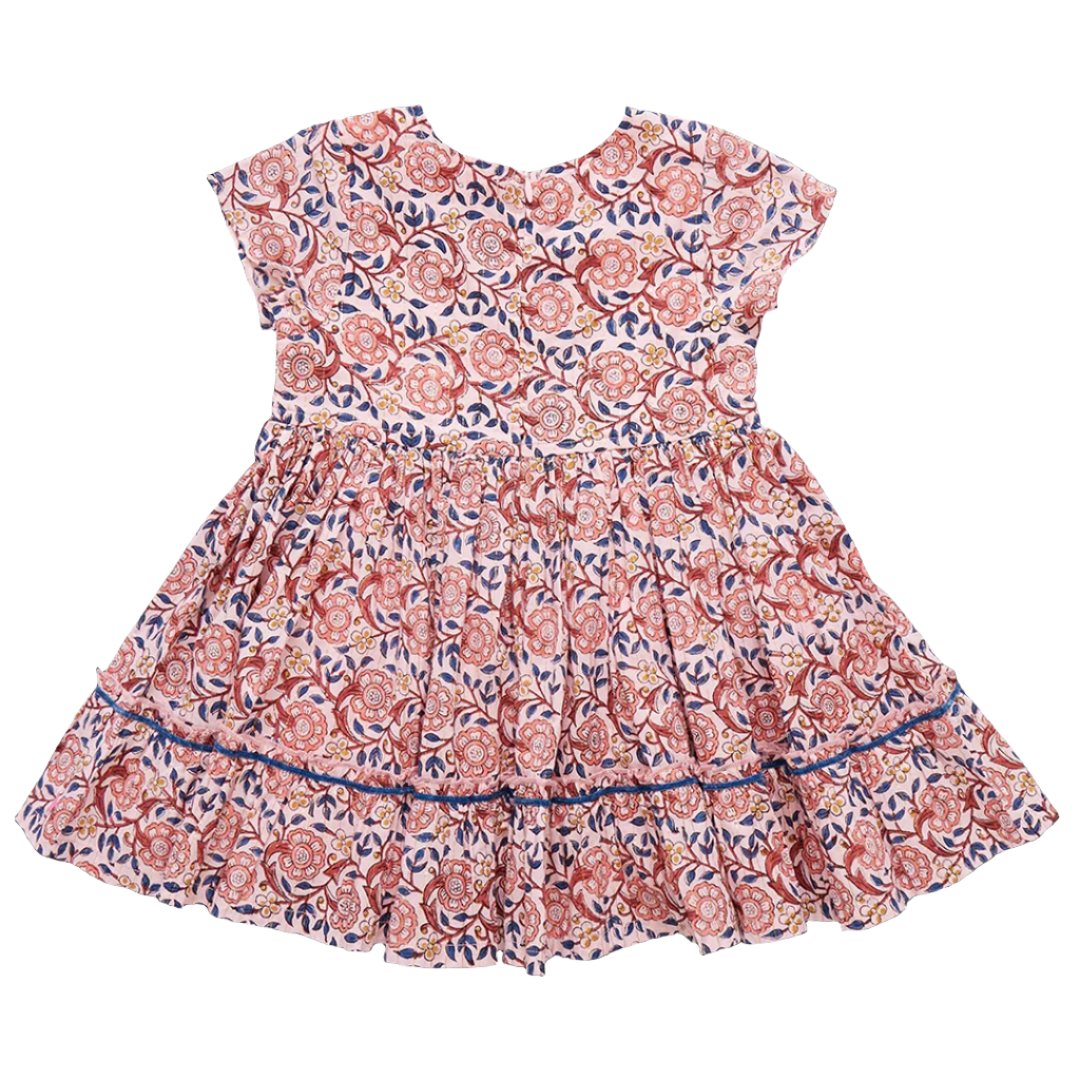 The Pink Chicken Girls' Niley Dress is a short-sleeved, knee-length dress with a floral pattern in shades of pink, orange, and blue. It features a gathered skirt and is displayed flat against a white background.