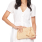 A woman in a short-sleeve white dress holds the Mar Y Sol Noa Clutch, featuring tassel accents—the ideal accessory for warm weather getaways—against a plain background.