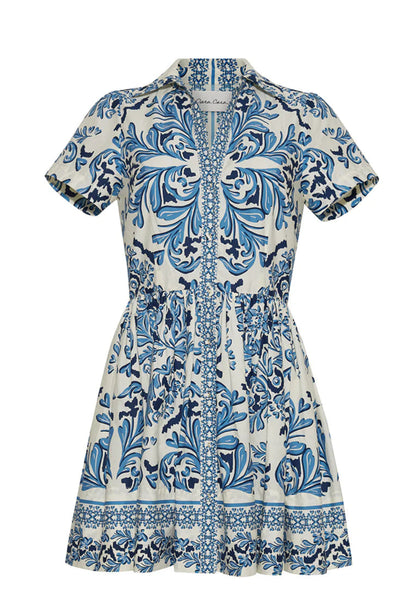 The Noor Mini Dress by Cara Cara features short sleeves, a collared design, blue and white floral and geometric patterns, a fitted waist with subtle darts, and a flared skirt for a fresh, charming look.