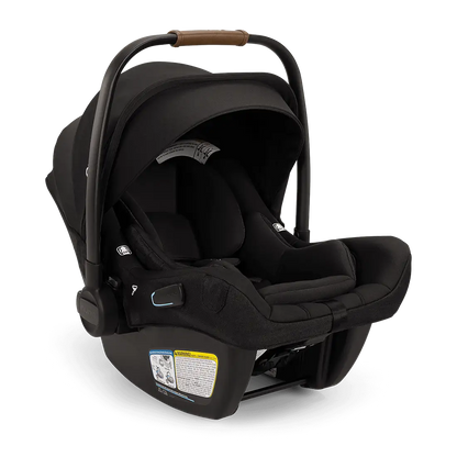 The Nuna Pipa Aire RX Carseat by Nuna is a black, lightweight infant car seat featuring a canopy and handlebar with brown accents. Crafted from machine washable fabrics, the seat includes a label with safety information and visible adjustment mechanisms on the sides. It is also FAA certified, providing peace of mind during travel.