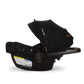 Side view of a black Nuna Pipa Aire RX Carseat featuring a canopy, safety labels, carrying handle, and advanced security features.