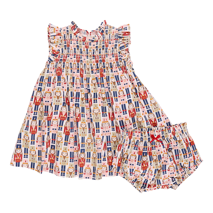 A vibrant Stevie Dress and matching bloomers by Pink Chicken, adorned with a Nutcracker-themed print featuring various Nutcracker characters in a repeated pattern.