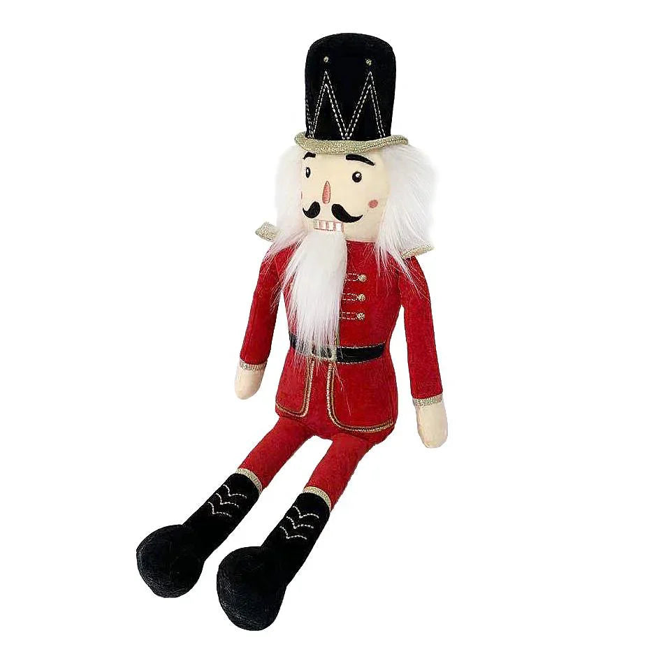 The MON AMI The Nutcracker Shelf Sitter - Large Red, crafted from soft polyester by Mon Ami, showcases a black hat, white hair, and a red uniform while sitting with its legs extended. This plush doll makes perfect holiday decor.