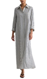 A person wearing the TWP Jenny's Clear Sequin Stripe Gown with vertical stripes, long sleeves, a collared neckline, and a button-up front, stylishly paired with black sandals.
