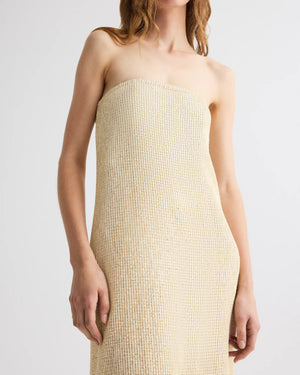 Someone models the Carolyns Sequin Netting Gown by TWP, a strapless beige maxi dress, against a plain background.