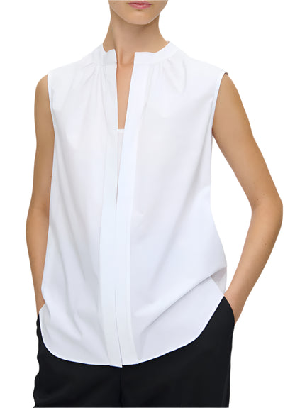 Wearing the Olympia Sleeveless Top by Callas Milano in white, paired with black pants and hands in pockets, exudes a modernist appeal.