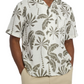A person is wearing Onia's Air Linen Vacation Shirt, featuring a relaxed-fit with short sleeves, adorned in a gray tropical leaf pattern on white fabric. It's perfectly paired with beige pants, making an ideal vacation outfit.
