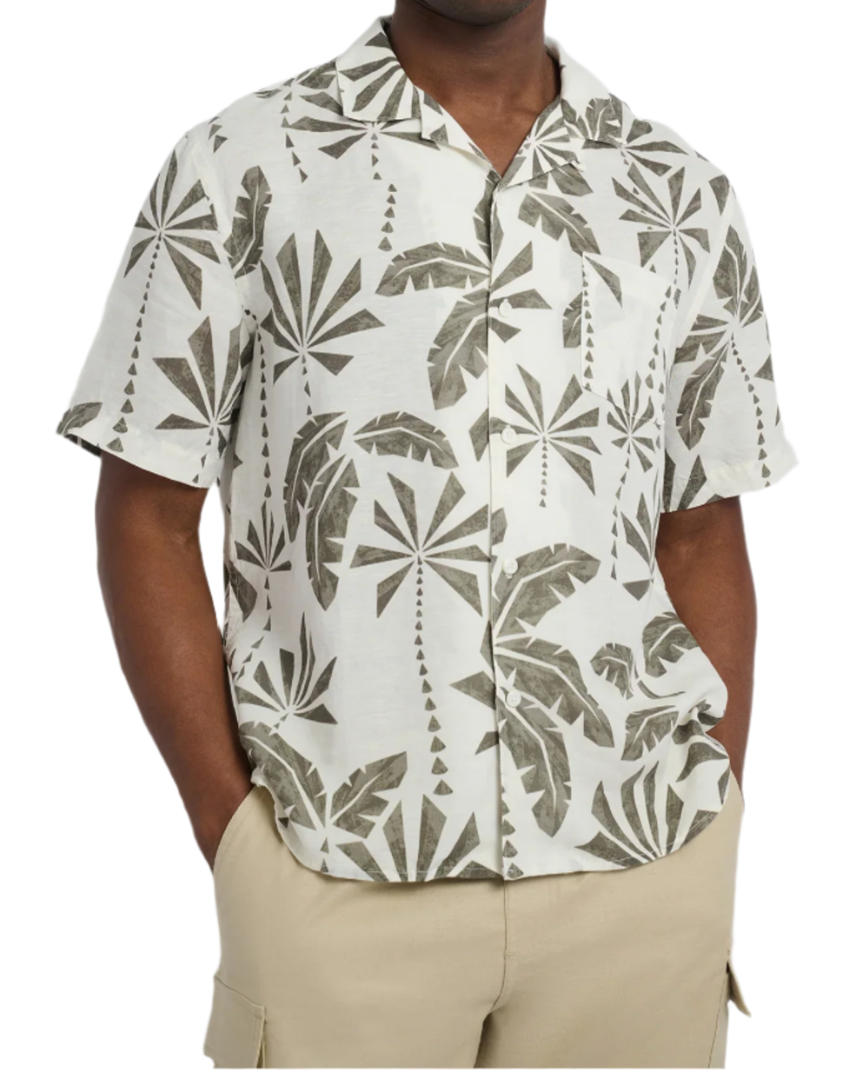 A person is wearing Onia's Air Linen Vacation Shirt, featuring a relaxed-fit with short sleeves, adorned in a gray tropical leaf pattern on white fabric. It's perfectly paired with beige pants, making an ideal vacation outfit.