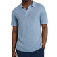 Standing against a white background, they wear Onia's Linen Sweater Polo in light blue with dark blue pants, one hand in the pocket. The outfit offers a relaxed fit ideal for any casual outing.