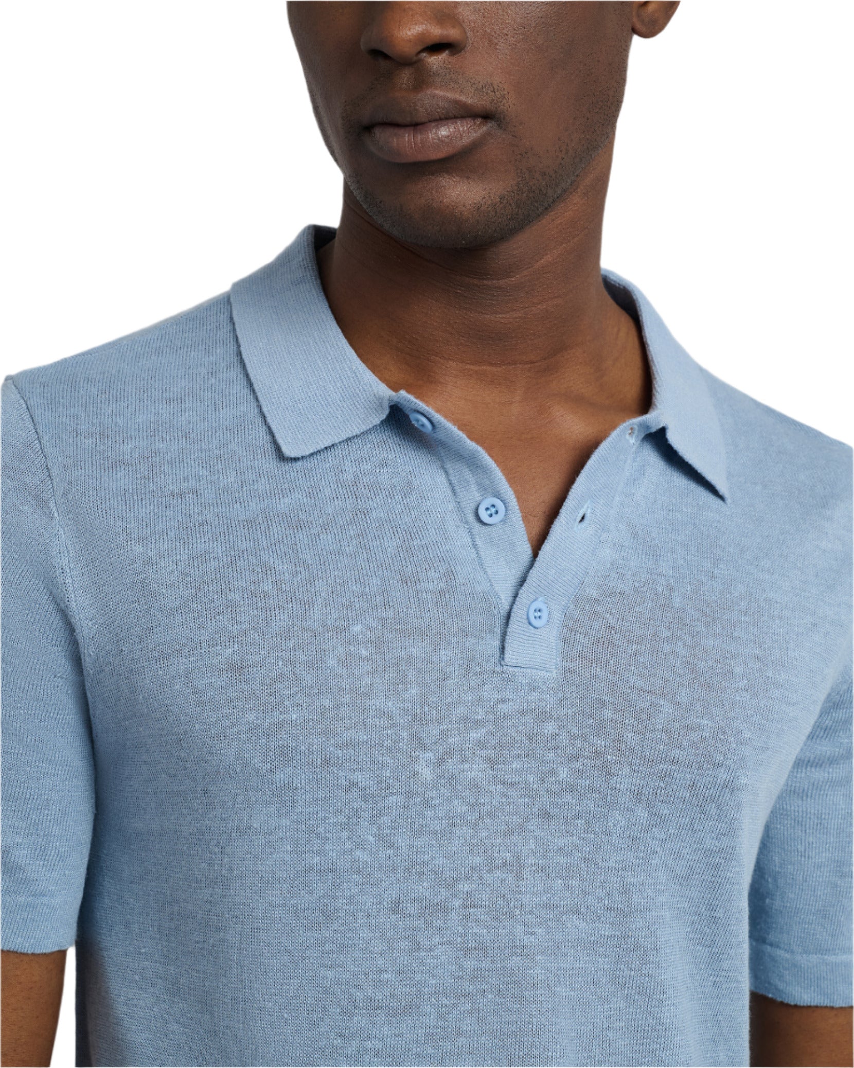 A man models the Onia Linen Sweater Polo, featuring a light blue, relaxed fit and short sleeves. It's crafted from linen jersey knit and showcased against a plain white background.