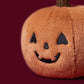 Close-up of the Jellycat Ooky Jack O’ Lantern, a plush pumpkin featuring an embroidered, smiling Jack O’ Lantern face on a burgundy background—perfect for bringing Jellycat charm to your next Halloween party.