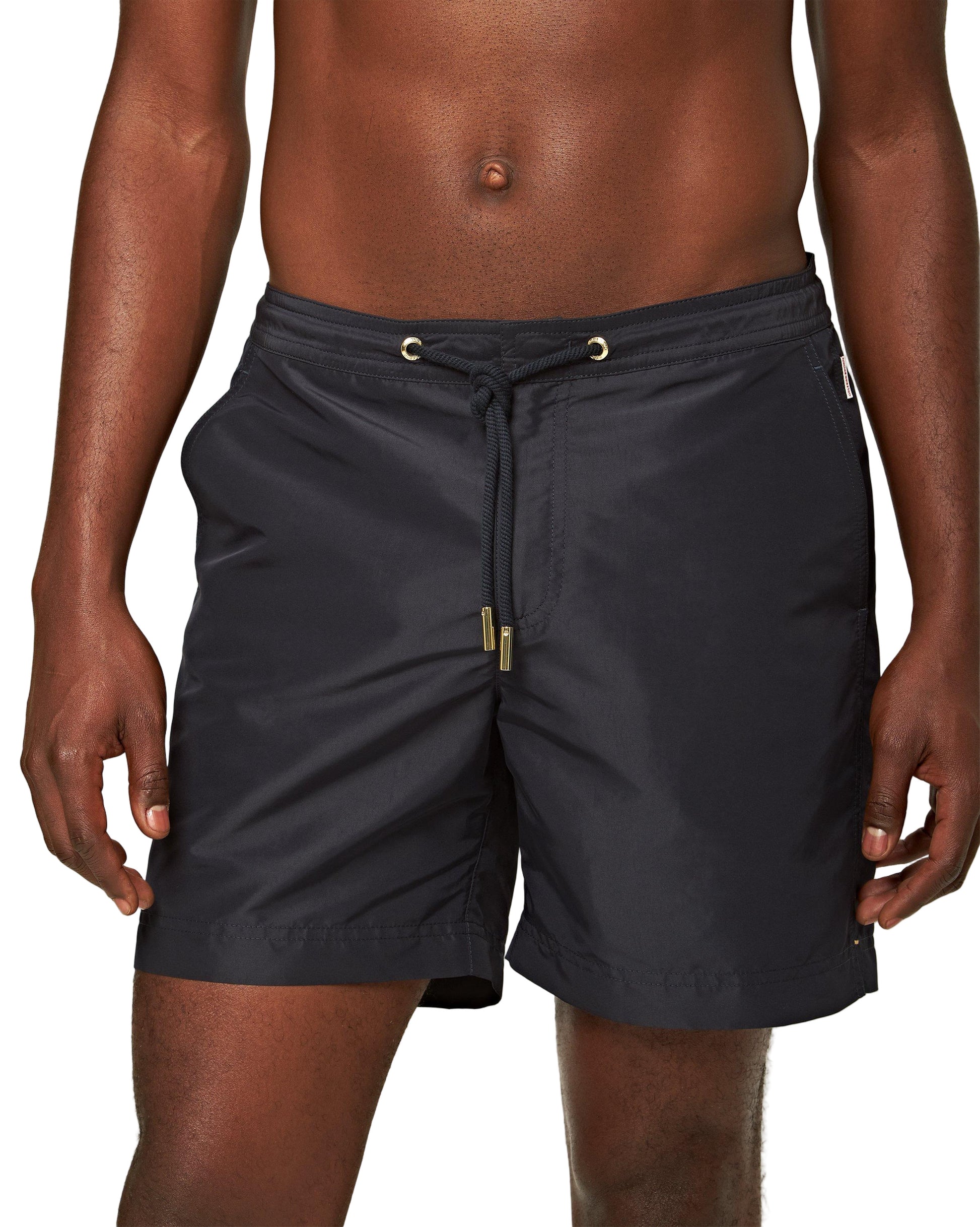 A man wears the Orlebar Brown Bulldog Drawcord Short, featuring a tailored fit and drawstring waist, standing against a plain white background.
