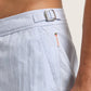 Close-up of a person wearing Orlebar Brown Bulldog Swim Shorts in Surfside Blue, featuring a side buckle and a small tag near the pocket.